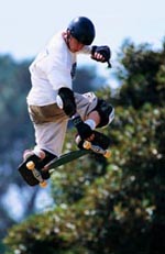 Picture of a young boy, in protective gear, skateboarding